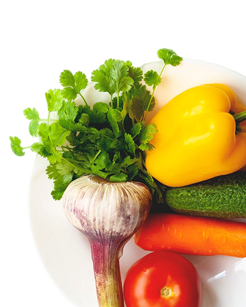 Garlic herbs yellow pepper cucumber carrot and tomato on a plate