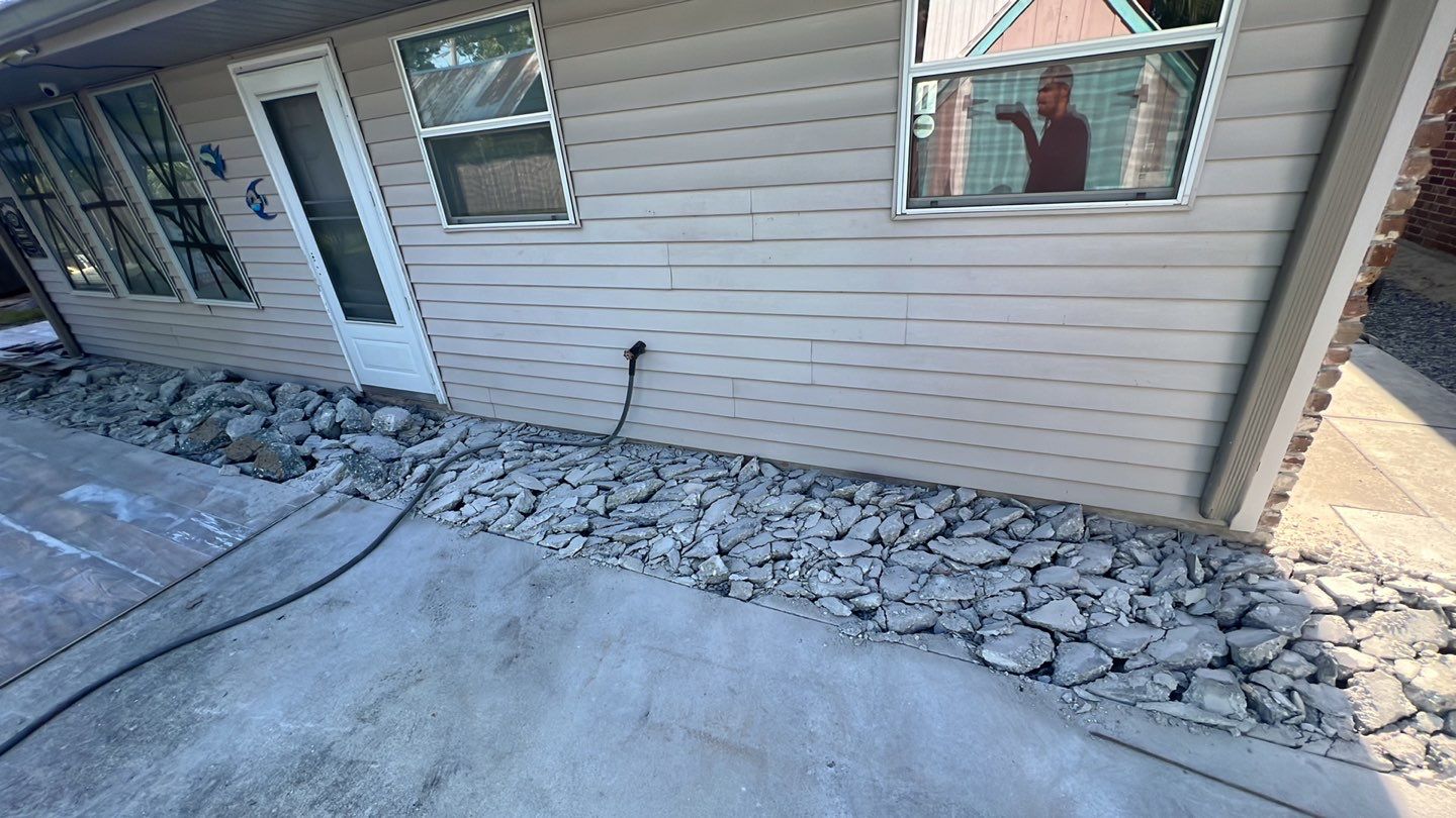 A house with a foundation repair and rocks in front of it.