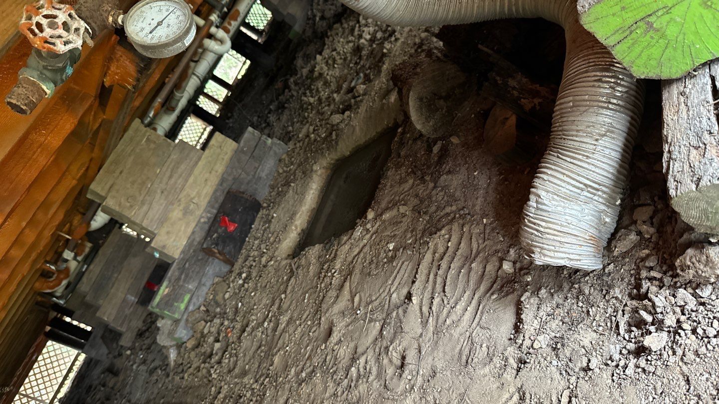 A view of a room with a wooden floor and a pipe.
